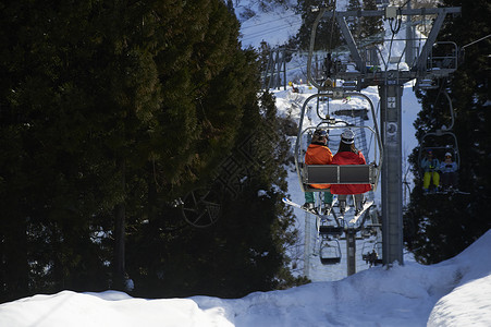 滑雪场上坐缆车的情侣背影图片