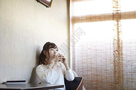 坐在休息室里喝咖啡的年轻女性图片