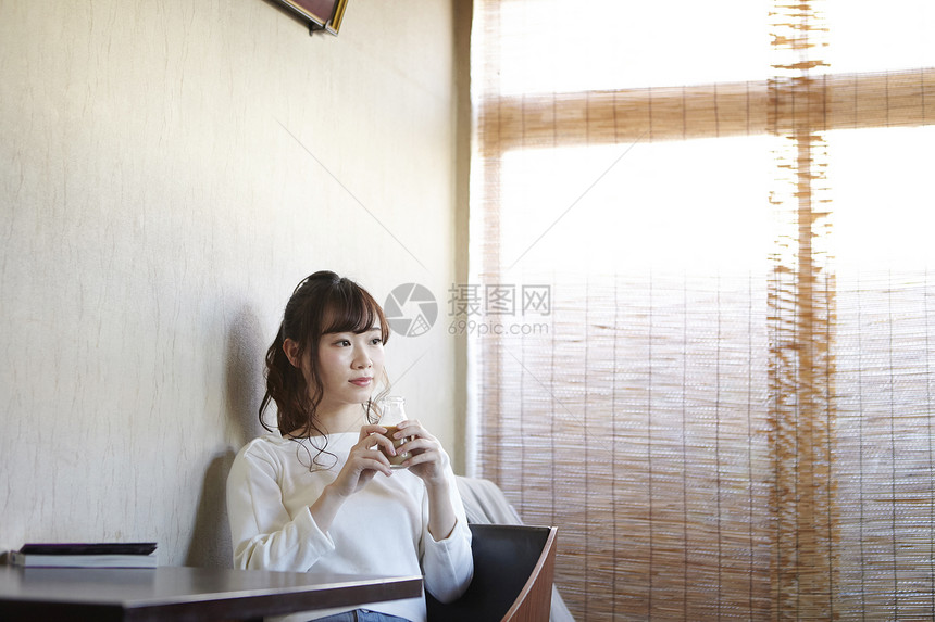 坐在休息室里喝咖啡休息的年轻女性图片