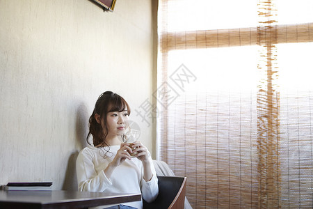 坐在休息室里喝咖啡休息的年轻女性图片