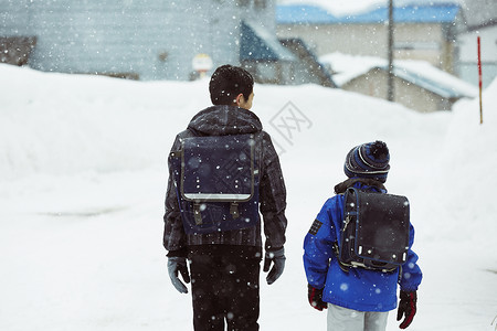 背着书包行走在雪地里的学生背影图片