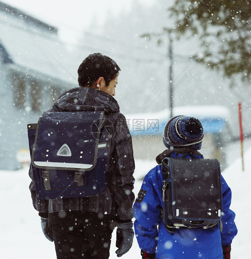 下雪天背着书包行走的学生背影图片