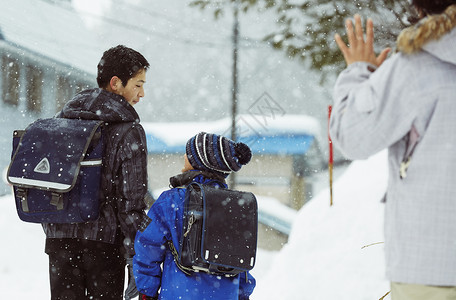 雪天背着书包上学的孩子图片