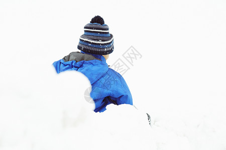 雪地上玩耍的小男孩背影图片