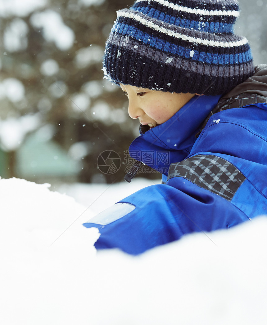 雪地里玩耍的小男孩图片