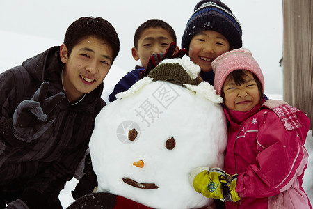 和雪人开心合影的孩子们图片