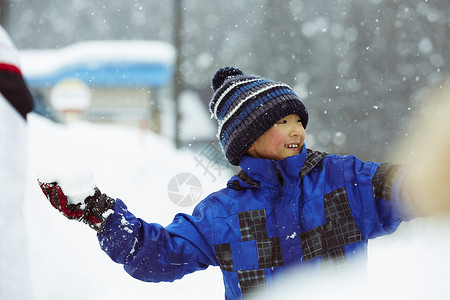 雪地里打雪仗玩耍的小男孩高清图片