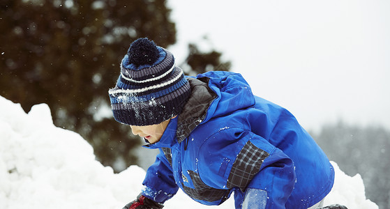 雪地里玩耍的小男孩图片