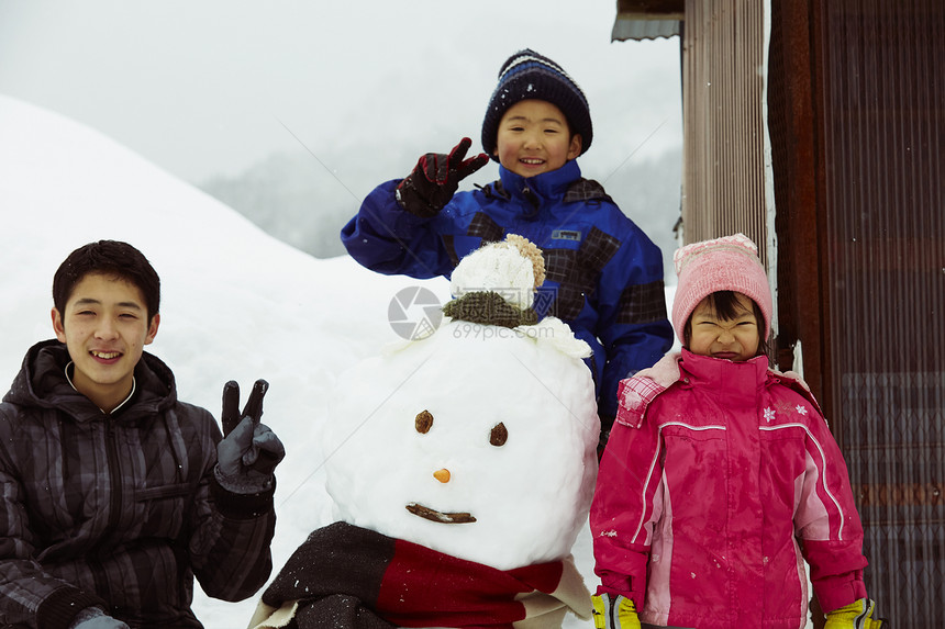 户外和雪人开心合照的孩子们图片