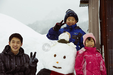 开心和雪人合照的孩子们图片