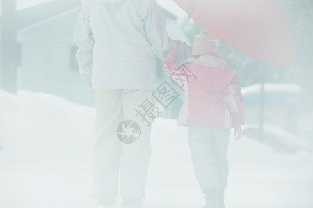 雪地里撑着伞的母女图片