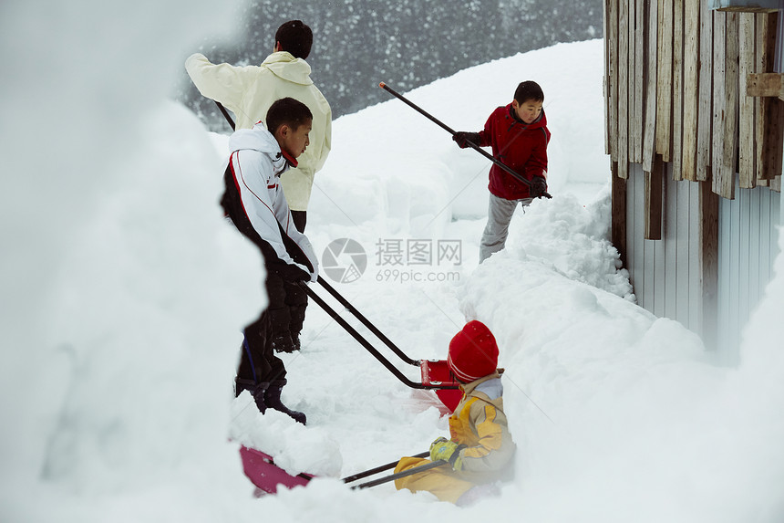 雪地里使用雪铲除雪的孩子们图片