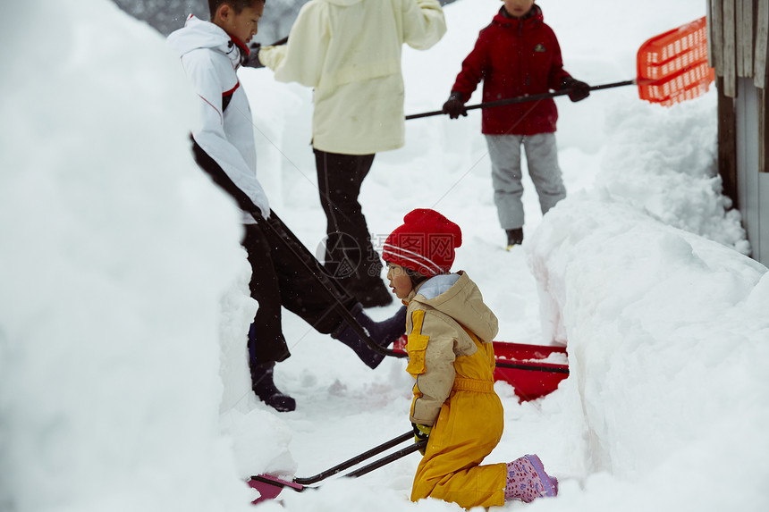 雪地里使用雪铲除雪的孩子们图片