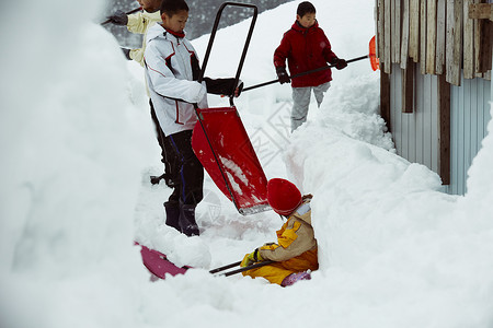 雪地里使用雪铲除雪的孩子们图片