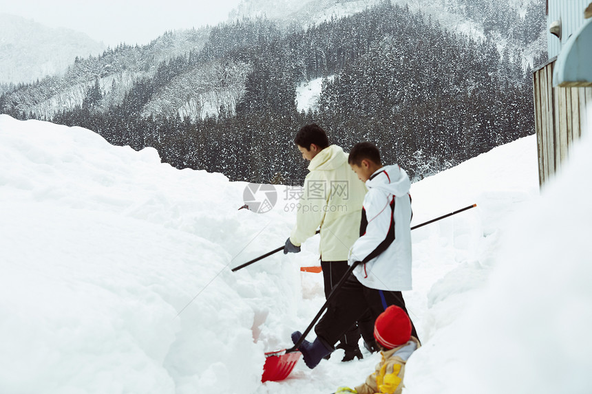 户外使用雪铲除雪的孩子们图片