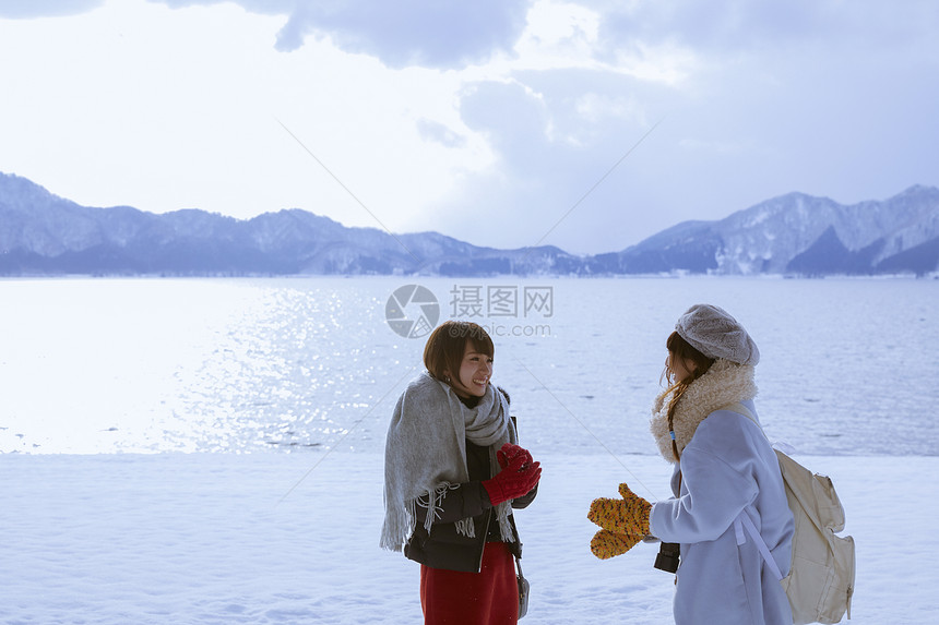 雪景区湖畔玩耍的少女们图片