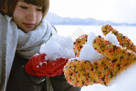 双手捧着雪的少女图片