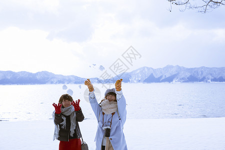 冬季旅程雪景区湖畔玩耍的少女图片