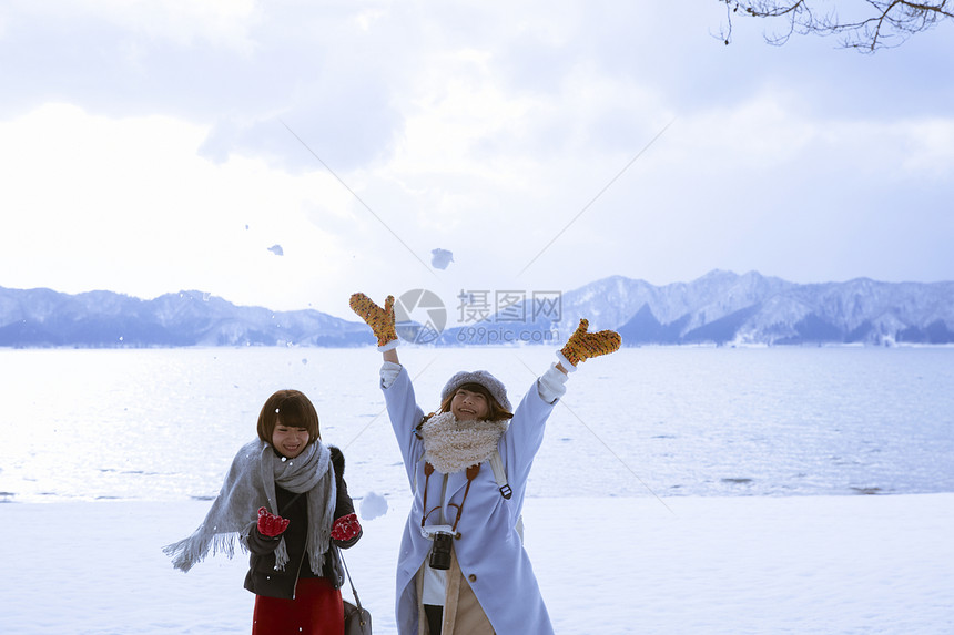 冬季旅程雪景区湖畔玩耍的少女图片