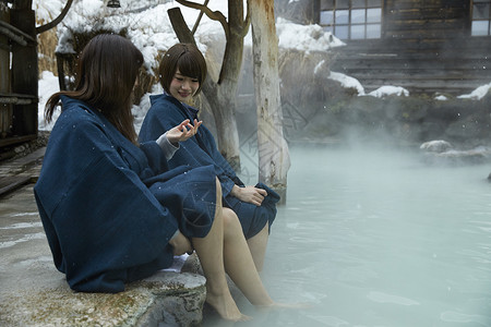 雪天温泉冬季雪天户外泡温泉的少女背景