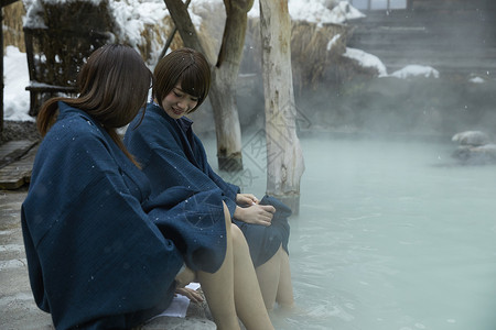 温泉区冬季雪天户外泡温泉的少女背景