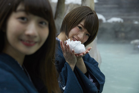 黑池冬季雪天户外泡温泉的少女背景