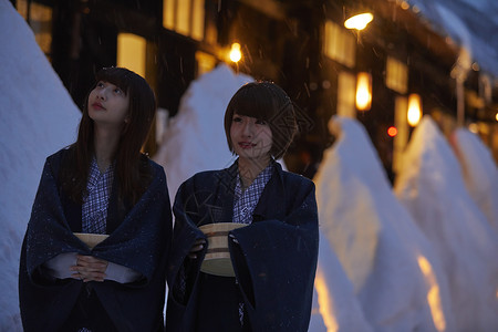 下雪的夜晚温泉度假酒店散步的少女图片