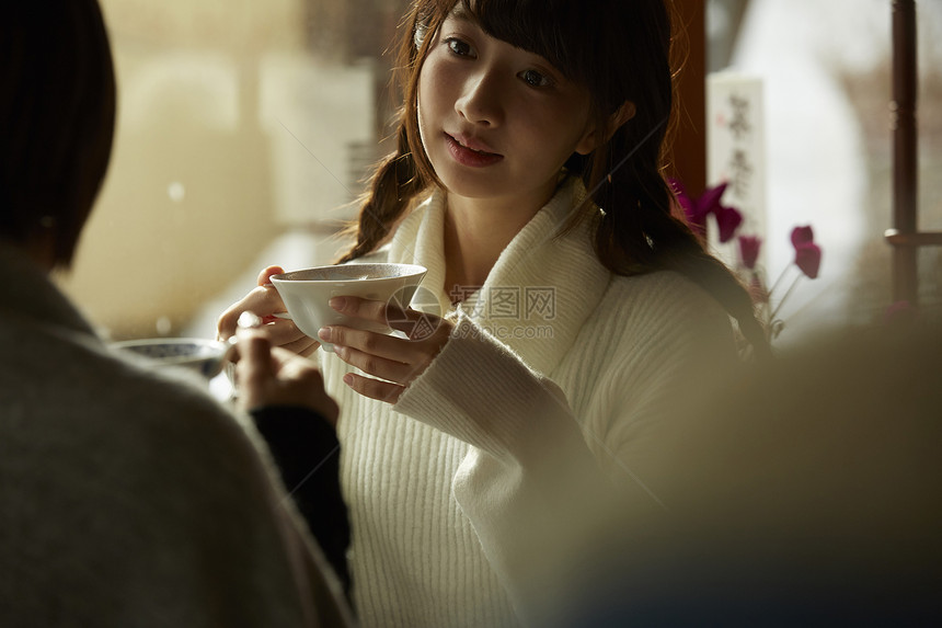 冬季穿着毛衣在咖啡馆喝咖啡的女学生图片