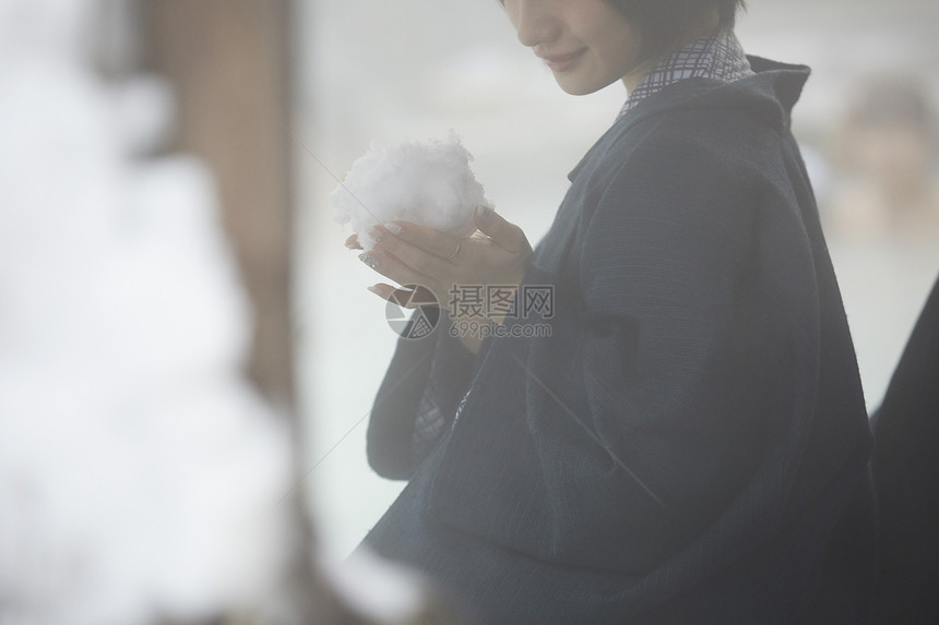 户外温泉捏着大雪球的女孩图片