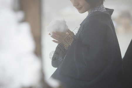 户外温泉捏着大雪球的女孩图片