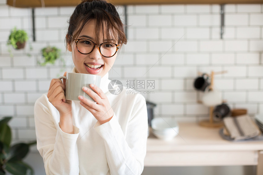 年轻女孩在厨房喝茶图片