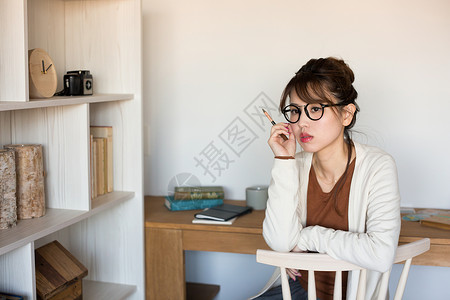 戴眼镜的女孩在书房拿着笔图片