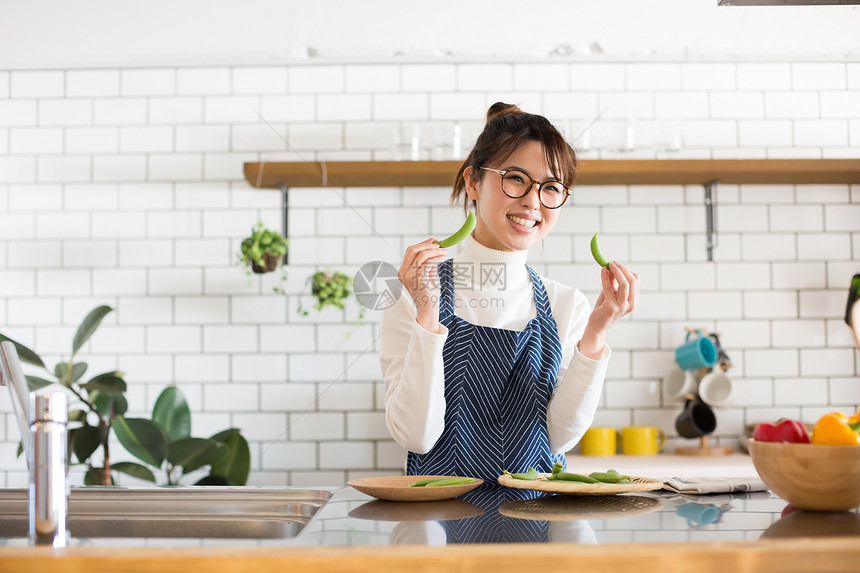 戴眼镜的女孩穿着围裙烹饪图片