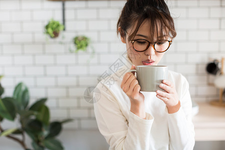 拿着水杯喝水的年轻女性图片