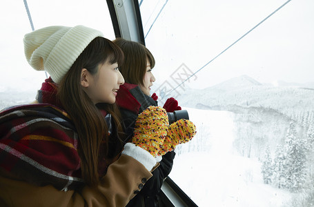 乘坐缆车看向窗外风景的少女图片