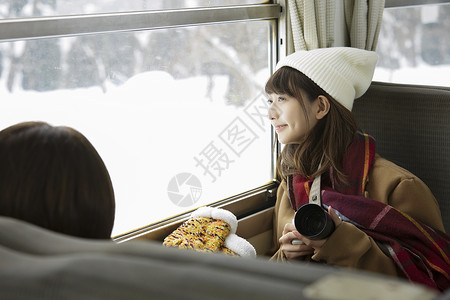冬季女学生看向窗外的雪图片