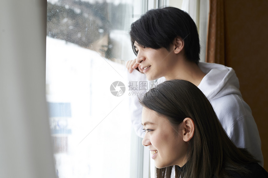 情侣在酒店看窗外雪景图片