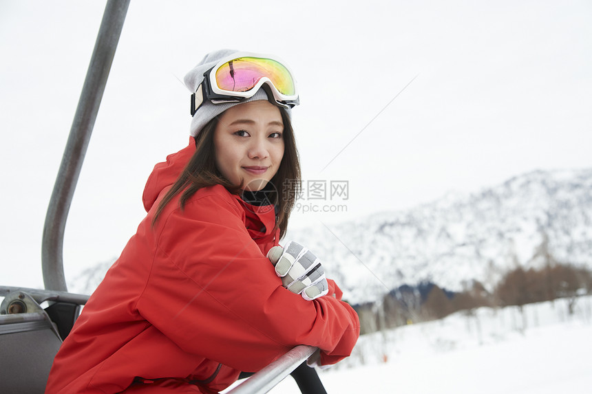 乘坐缆车到雪山顶的年轻女性图片