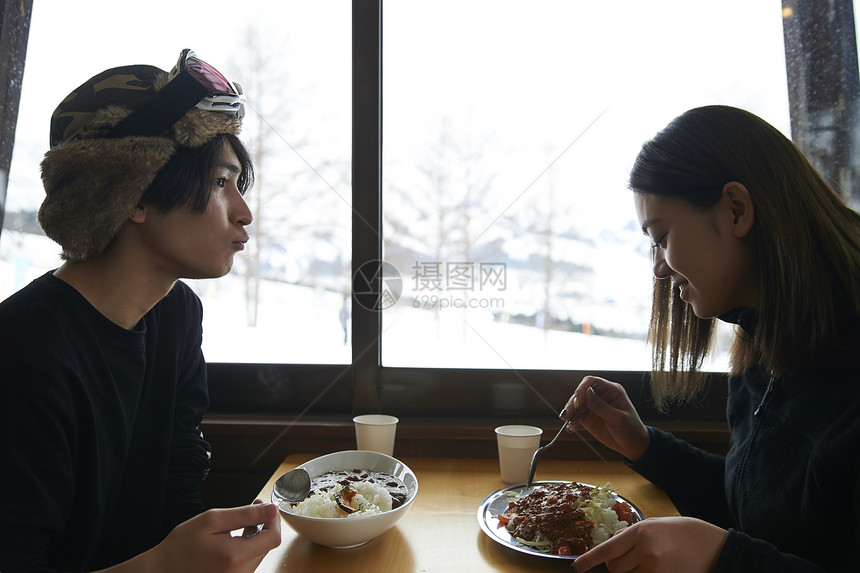 滑雪场享用午餐的年轻夫妇图片