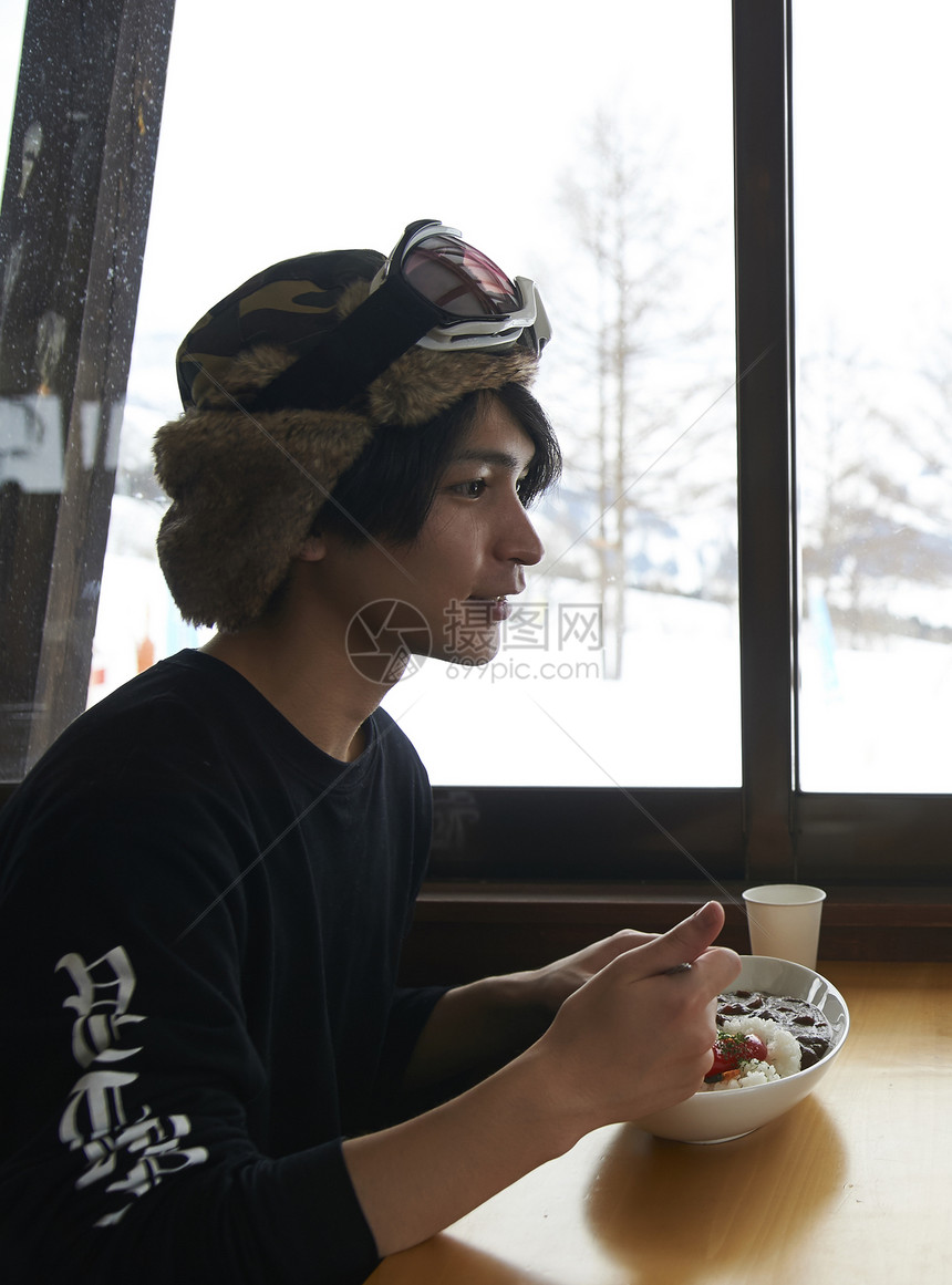 滑雪场餐厅享用午餐的男性图片