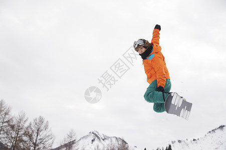 滑雪场展示技术的单板男孩图片