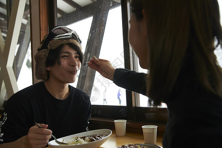 滑雪场享有午餐互喂的夫妇图片