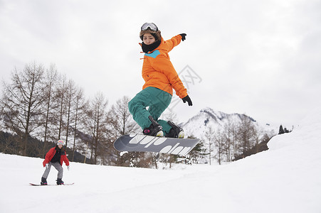 滑雪场展示高难度的单板男孩背景图片