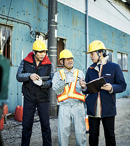 在建筑工地检查作业的蓝领工人图片