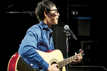 男人在舞台上演奏弹吉他背景图片