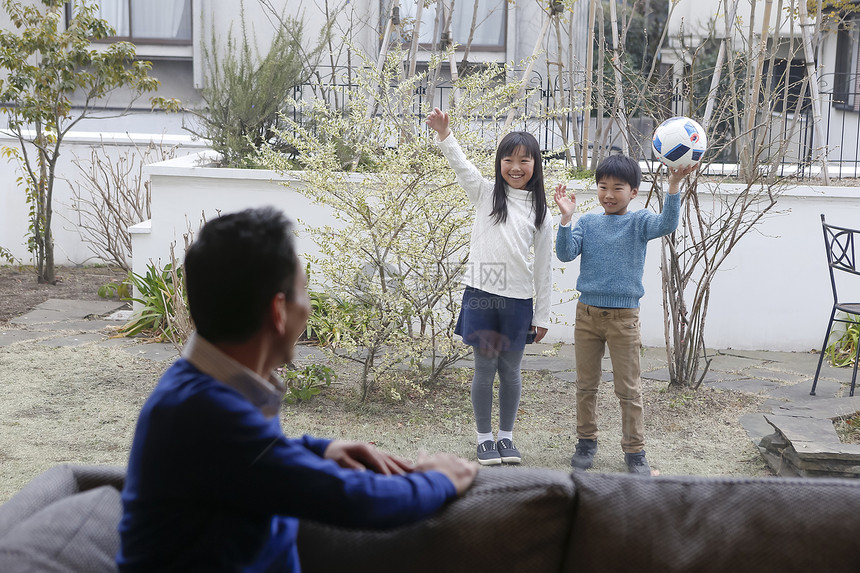 父亲和户外庭院玩耍的孩子们打招呼图片