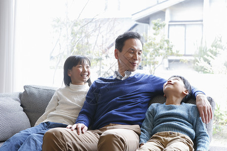 父亲和两个小孩在客厅沙发上躺着图片