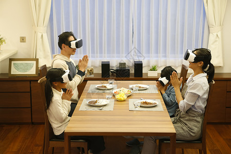 吃饭时带着VR眼镜的一家四口图片