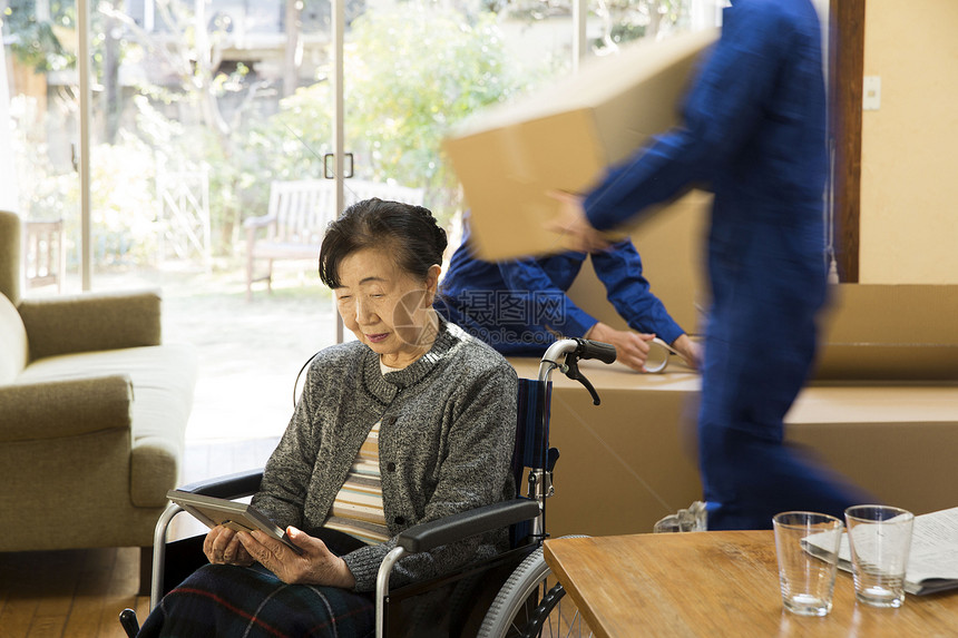 年迈的女士坐在轮椅上看相片图片