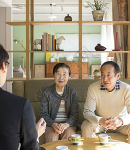 年迈夫妇在家和商务人士洽谈图片